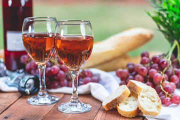 Wine, Grapes, and French Bread on a Picnic Table