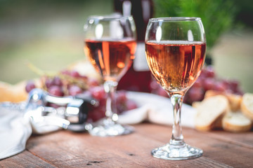 Glasses of wine on a rustic wooden picnic table