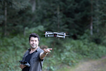 Professional drone pilot controlling his drone in a forest