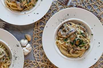top down photo of a mushroom spaghetti meal for 3 in a rustic place setting