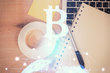 Blockchain theme hologram drawings over computer on the desktop background. Top view. Multi...