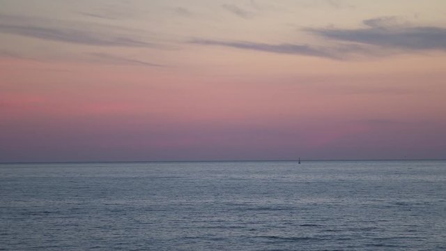 Sailboat in lake water sunset, pastel pink purple sky skyline horizon, dusk stratus clouds wide Lake Huron Ontario static