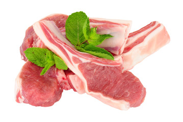 Group of fresh raw lamb cutlets with mint leaf garnish isolated on a white background