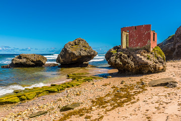 A ruined building on a wave-cut boulder on the shore of Bathsheba Beach on the Atlantic coast of Barbados