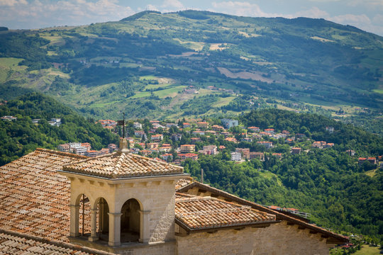 Old Ceramic Tile, roof. View of the surroundings of the Republic of San Marino. Chimneys and stormwater, lightning rods. mountains and fields in the background. Italy
