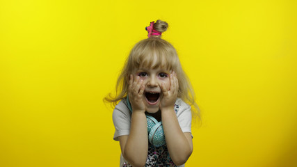 Child show amazement, fooling around, smiling, looking surprised shocked on yellow background