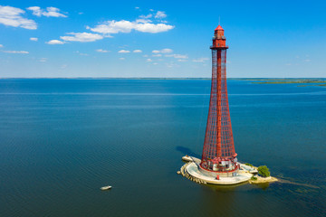 aerial view to red lighthouse at the sea with blue sky and copy space