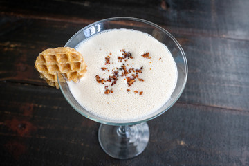 Maple Syrup Cocktail with Garnish: A sweet and creamy cocktail made with dark rum and maple syrup then topped with bacon bits and a mini waffle garnish