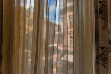 morning view from inside curtains in room interior object and opposite building outside