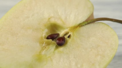 Green apple with seeds, cut in half. Macro shot. Dolly Shot