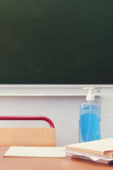 Class closed for isolation due to virus quarantine. School desk with disinfectants and antibacterial soap.