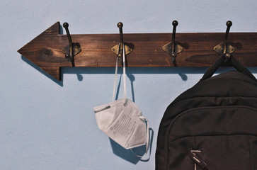 Backpack and covers mouths hung on a clothes rack for the return to school during quarantine.