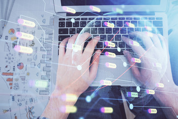Multi exposure of man's hands typing over computer keyboard and world map hologram drawing. Top view. Technology concept.