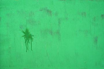 Full-screen texture of a roughly painted green metal sheet with a dark blot