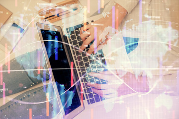 Double exposure of woman hands working on computer and financial theme hologram drawing. Top View. Business concept.