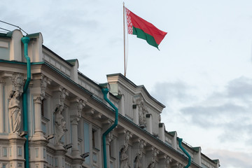 National flag of the Republic of Belarus are waving at wind on cloudy sky.