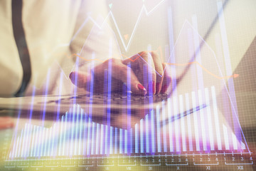 Double exposure of businesswoman hands typing on computer and financial graph hologram drawing. Stock market analysis concept.