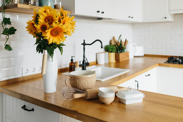 Dishes and utensils on kitchen table, ready to cook.
