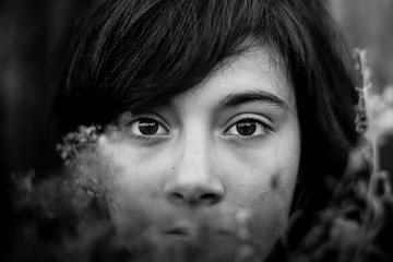 Close-up black-and-white portrait girl with expressive eyes.