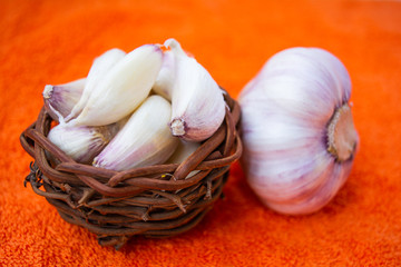 Cloves of raw Garlic in wooden small vintage nest as bowl. Spices for cooking