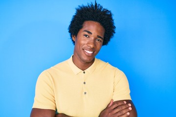 Handsome african american man with afro hair wearing casual clothes happy face smiling with crossed arms looking at the camera. positive person.