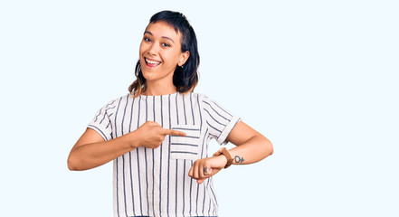 Young woman wearing casual clothes in hurry pointing to watch time, impatience, upset and angry for...