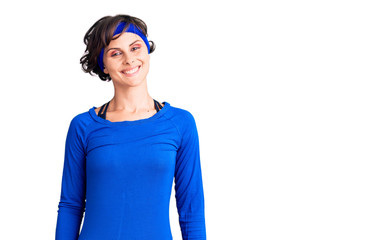 Beautiful young woman with short hair wearing training workout clothes with a happy and cool smile on face. lucky person.