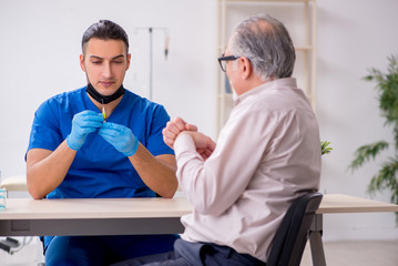 Obraz premium Old patient visiting young male doctor in blood transfusion conc