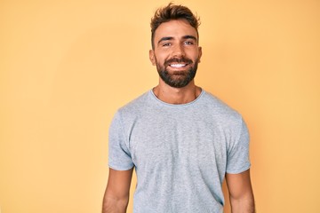 Fototapeta premium Young hispanic man wearing casual clothes looking positive and happy standing and smiling with a confident smile showing teeth
