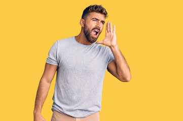 Young hispanic man wearing casual clothes shouting and screaming loud to side with hand on mouth....