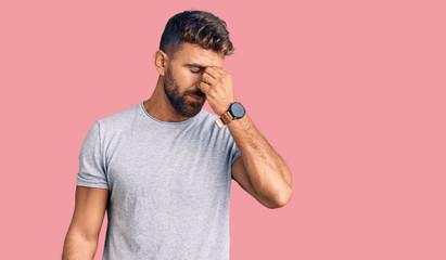 Young hispanic man wearing casual clothes tired rubbing nose and eyes feeling fatigue and headache. stress and frustration concept.