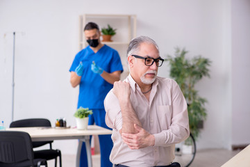 Fototapeta premium Old patient visiting young male doctor in blood sampling concept