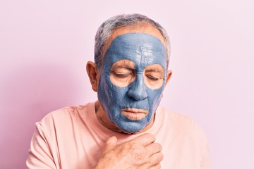 Senior man with grey hair wearing mud mask feeling unwell and coughing as symptom for cold or bronchitis. health care concept.