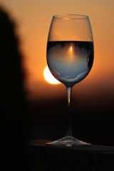 Reflection of the beautiful orange sunset in a glass of wine.