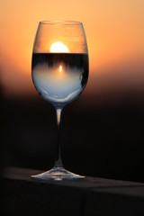 Romantic view and wine glass with the reflection of a beautiful sun and sunset.