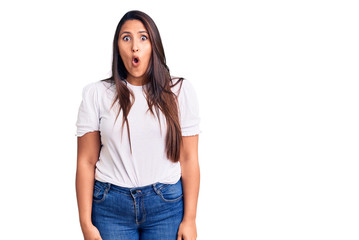 Young beautiful brunette woman wearing casual t-shirt scared and amazed with open mouth for surprise, disbelief face