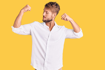 Fototapeta premium Young caucasian man wearing casual clothes showing arms muscles smiling proud. fitness concept.