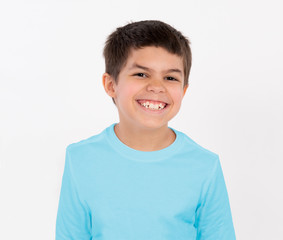 Portrait elementary school age young boy in blue t shirt smiling with happy expression