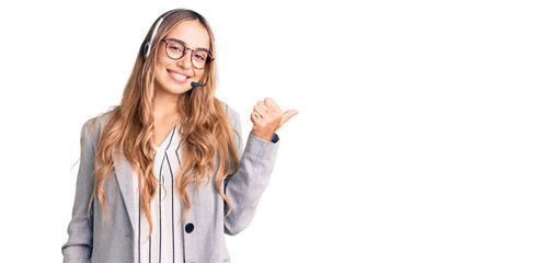 Young beautiful blonde woman wearing call center agent headset smiling with happy face looking and...