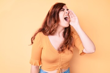 Young beautiful woman wearing casual clothes shouting and screaming loud to side with hand on mouth. communication concept.