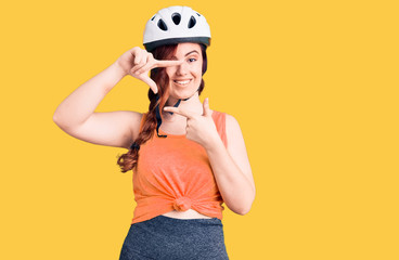 Young beautiful woman wearing bike helmet smiling making frame with hands and fingers with happy face. creativity and photography concept.