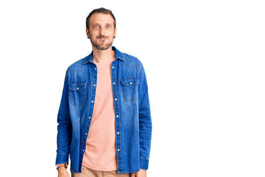 Young handsome man wearing casual clothes puffing cheeks with funny face. mouth inflated with air, crazy expression.