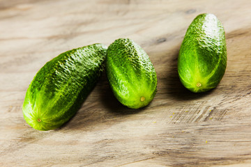 Cucumber on the grey wood textured background, fresh vegetables, summer in the garden.