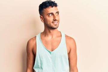 Young hispanic man wearing casual clothes looking to side, relax profile pose with natural face and confident smile.