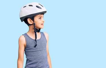 Little cute boy kid wearing bike helmet looking away to side with smile on face, natural expression. laughing confident.