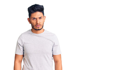 Handsome latin american young man wearing casual tshirt skeptic and nervous, frowning upset because...