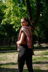 Young woman is resting after jogging in the park.