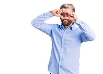 Young handsome blond man wearing elegant shirt doing heart shape with hand and fingers smiling looking through sign