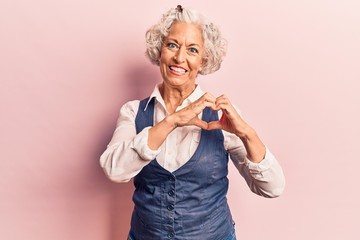 Senior grey-haired woman wearing casual clothes smiling in love doing heart symbol shape with hands. romantic concept.