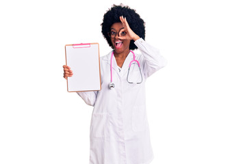 Young african american woman wearing doctor stethoscope holding clipboard smiling happy doing ok sign with hand on eye looking through fingers